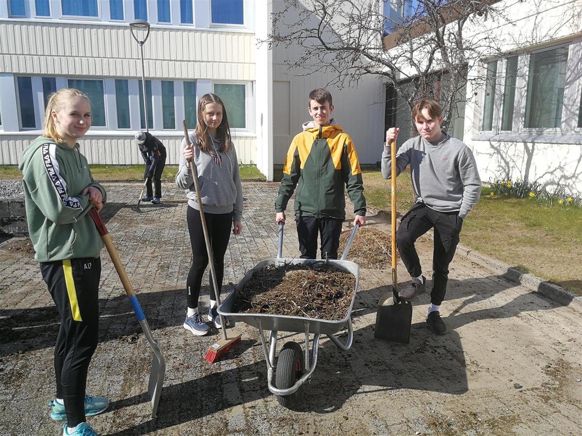 Fire elever rundt ei trillebår holder hageredskaper - Klikk for stort bilde